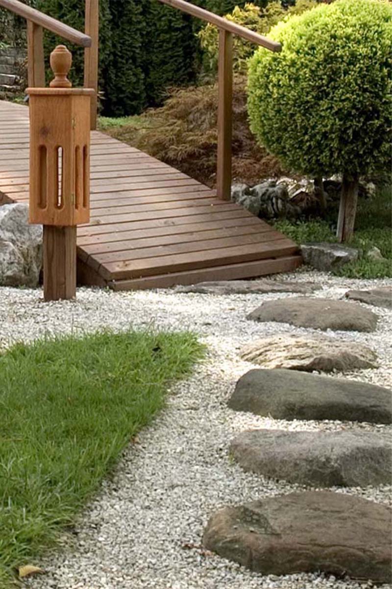 stone path leading to a wooden foot bridge